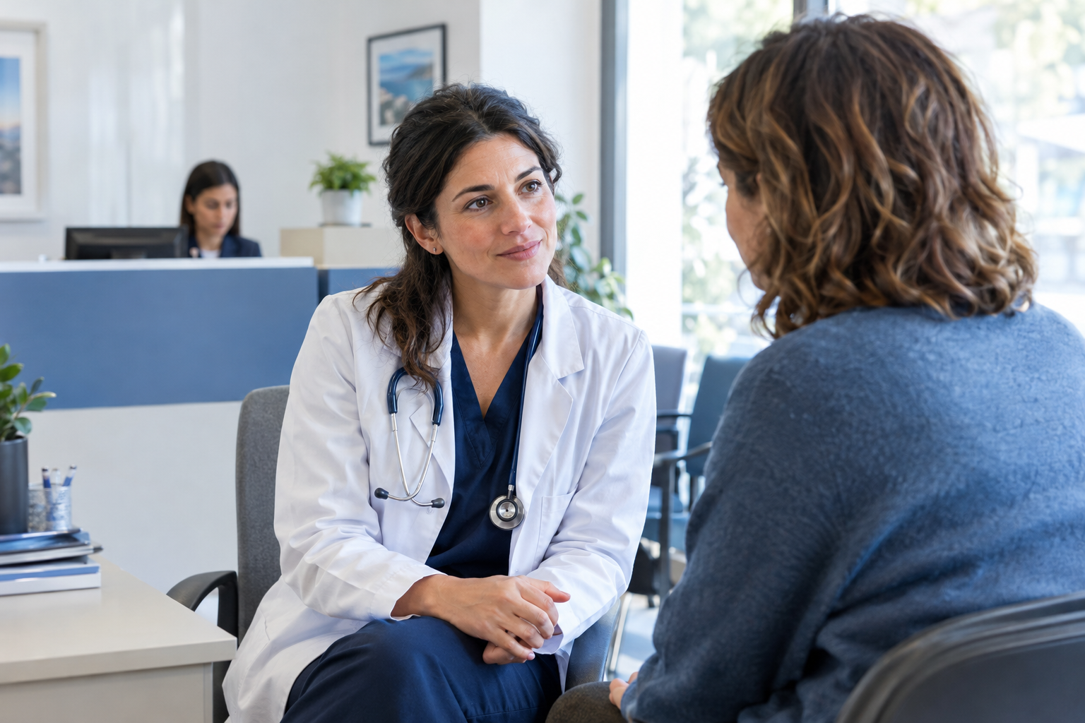 Medico di famiglia ascolta una paziente nello studio